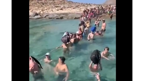 Niente molo per proteggere la spiaggia, turisti costretti a entrare in acqua con i bagagli sulla testa: il video