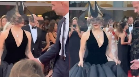 Lady Gaga sul red carpet, delirio alla Mostra del Cinema: firma più autografi possibile con cappello scultoreo e vestito vaporoso VIDEO