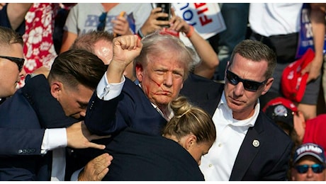 Trump ferito, gli spari, l'orecchio destro perforato, il pugno alzato e il messaggio ai suoi sostenitori: «Sono Donald e non mi arrenderò mai»